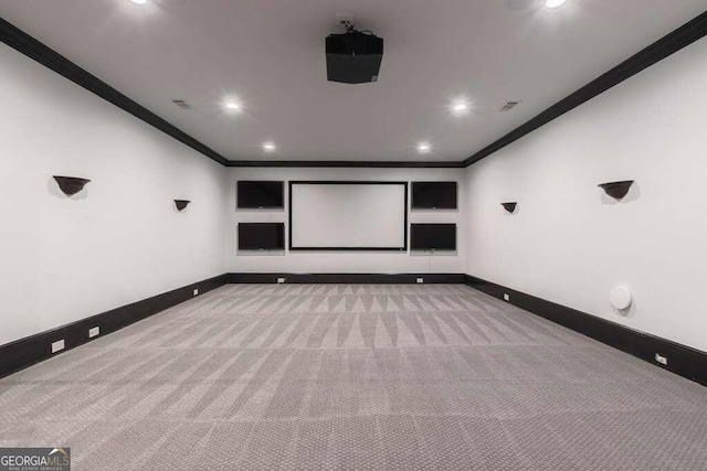 cinema room featuring ornamental molding and light colored carpet