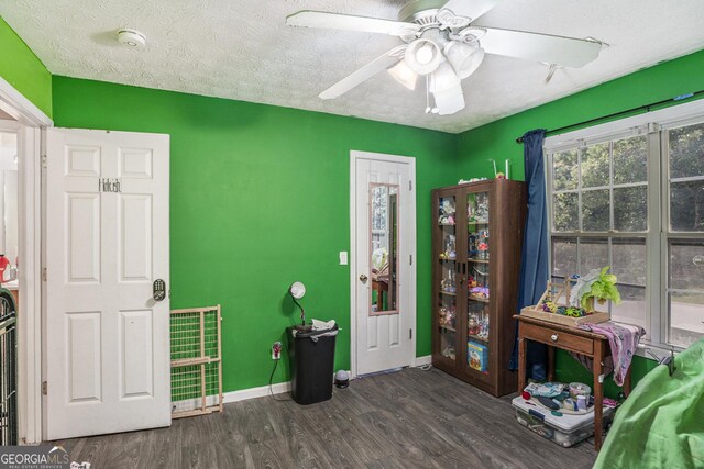 interior space featuring ceiling fan, dark hardwood / wood-style flooring, and a textured ceiling