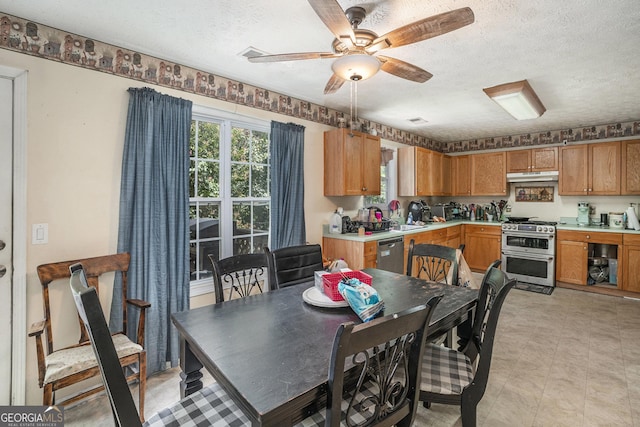 dining area featuring a textured ceiling, ceiling fan, and sink