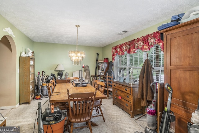 carpeted dining space featuring a notable chandelier and a textured ceiling