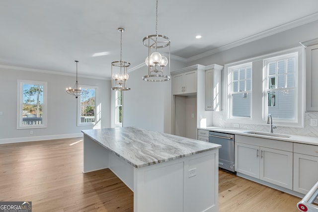 kitchen with light wood-type flooring, sink, pendant lighting, dishwasher, and a center island