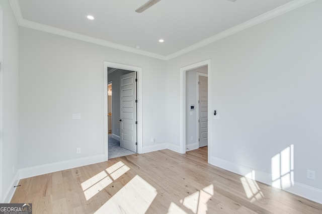 spare room featuring crown molding and light hardwood / wood-style floors