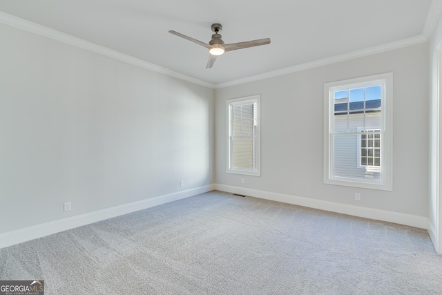 carpeted empty room featuring ceiling fan and crown molding