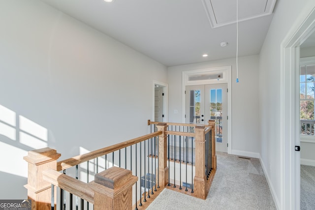 hallway with light carpet and french doors