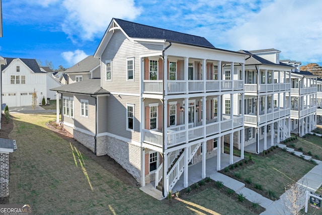 back of property featuring a yard, a balcony, and a patio