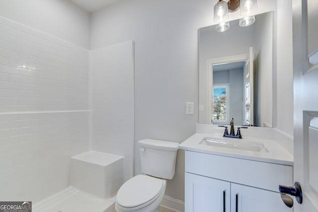 bathroom featuring toilet, vanity, and walk in shower