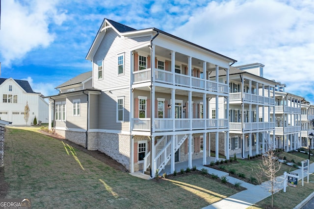 view of front of property with a front yard and a balcony