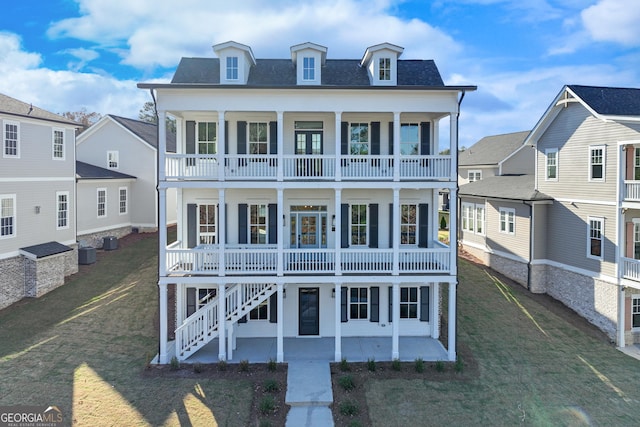 view of front of property with central AC unit, a patio, and a front yard