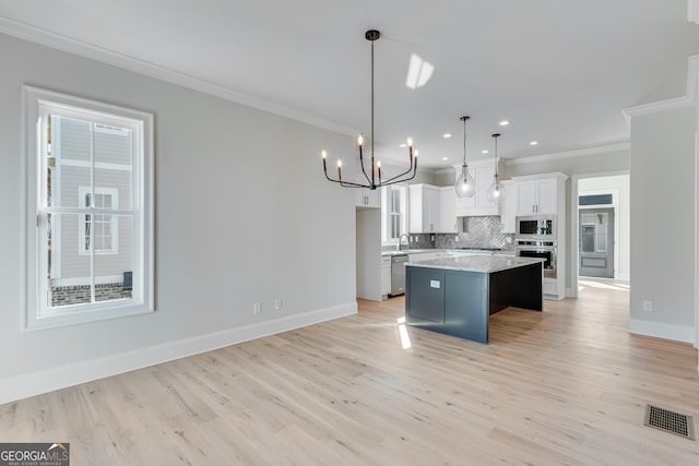 kitchen with a center island, hanging light fixtures, light hardwood / wood-style flooring, white cabinets, and appliances with stainless steel finishes