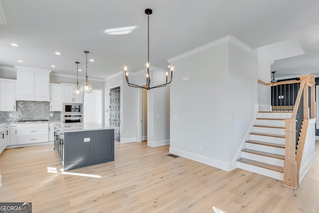 kitchen featuring white cabinetry, a center island, light hardwood / wood-style flooring, and appliances with stainless steel finishes