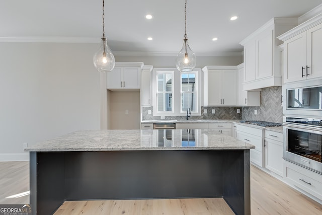 kitchen featuring stainless steel appliances, a kitchen island, and white cabinetry