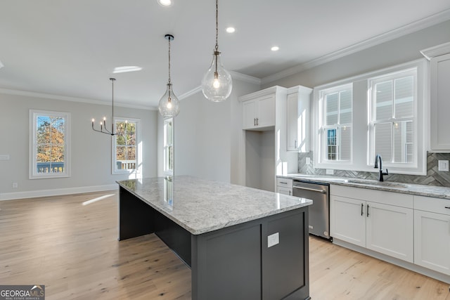 kitchen featuring decorative backsplash, white cabinetry, a kitchen island, and stainless steel dishwasher