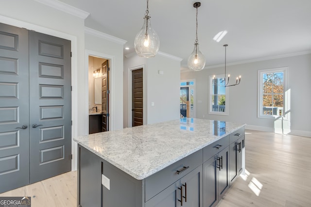 kitchen with a center island, light hardwood / wood-style floors, crown molding, and a wealth of natural light