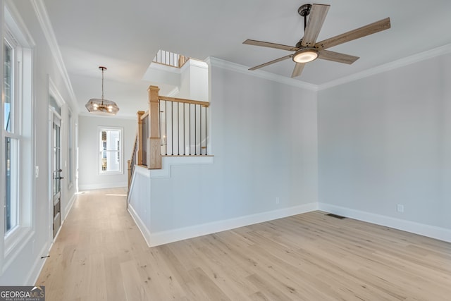 interior space featuring ceiling fan with notable chandelier, light wood-type flooring, crown molding, and french doors