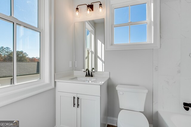 bathroom featuring plenty of natural light, vanity, and toilet