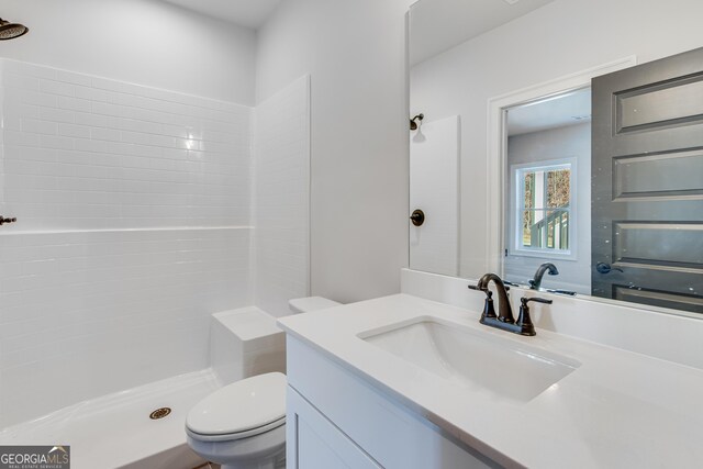 bathroom with a shower, vanity, and toilet