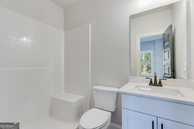 bathroom with walk in shower, vanity, and toilet