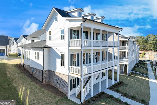 rear view of property featuring a lawn, a patio area, and a balcony