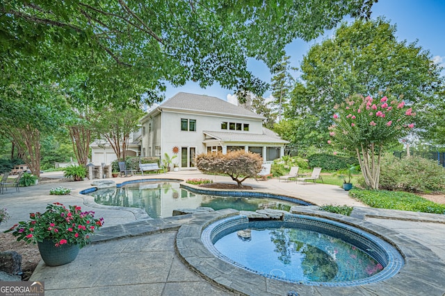 view of pool with a patio area and an in ground hot tub