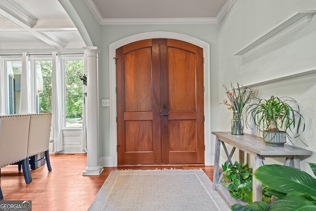 entryway featuring wood-type flooring, ornate columns, ornamental molding, and coffered ceiling