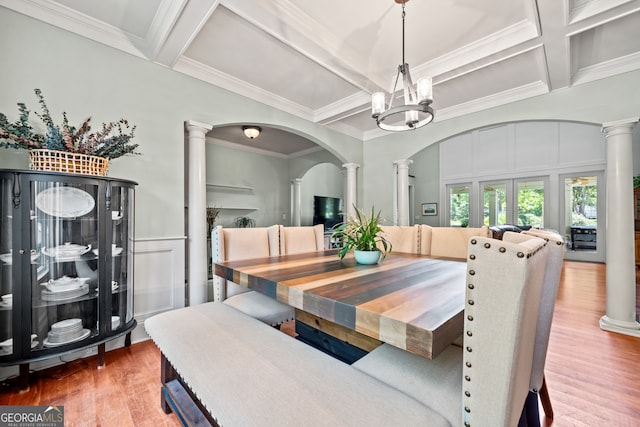 dining room featuring hardwood / wood-style flooring, a notable chandelier, coffered ceiling, and decorative columns