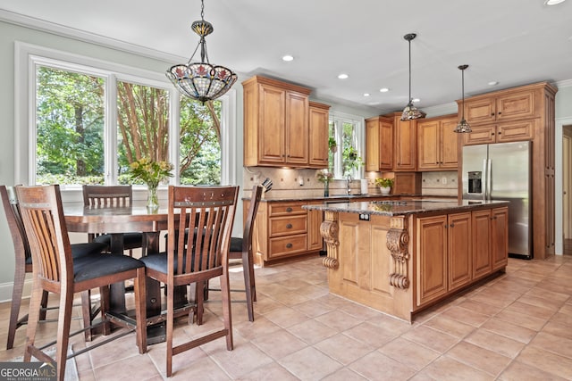 kitchen featuring decorative backsplash, a center island, hanging light fixtures, and light tile patterned floors