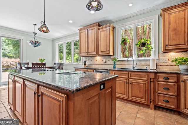 kitchen with sink, a healthy amount of sunlight, decorative light fixtures, a kitchen island, and light tile patterned flooring