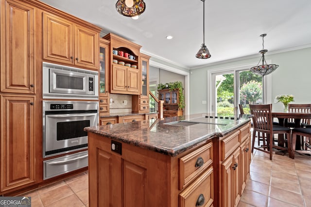 kitchen with light tile patterned floors, a center island, stainless steel appliances, pendant lighting, and ornamental molding