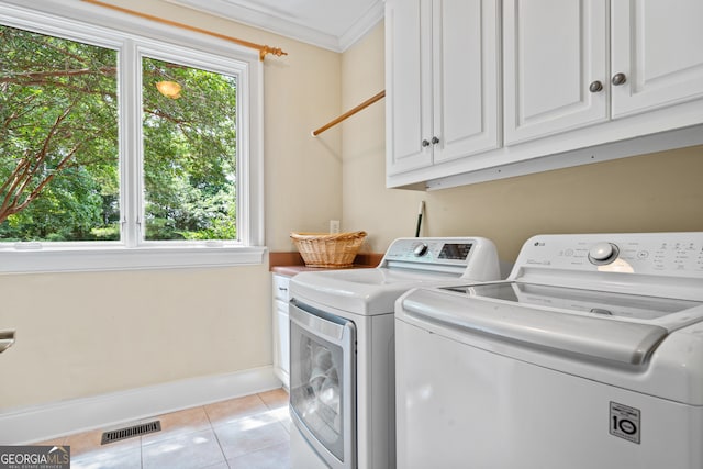 laundry area with washer and clothes dryer, crown molding, cabinets, and light tile patterned floors