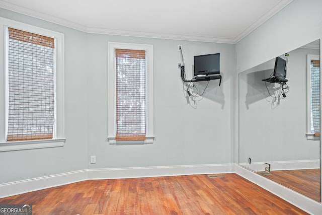 spare room featuring crown molding and hardwood / wood-style floors