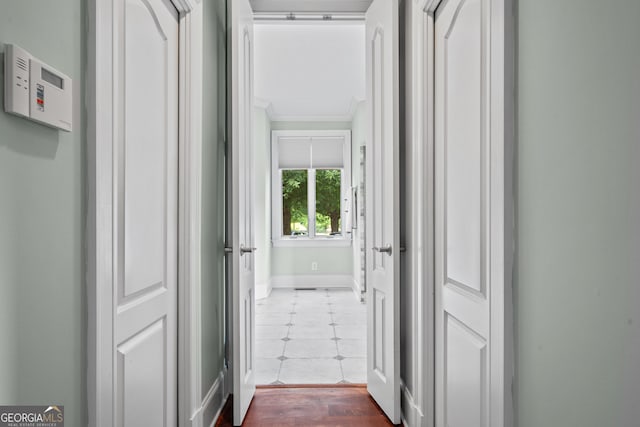 hallway with hardwood / wood-style flooring and crown molding