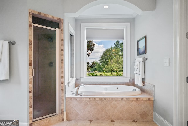 bathroom featuring independent shower and bath, ornamental molding, and a healthy amount of sunlight