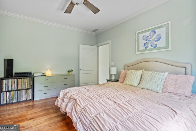 bedroom featuring ornamental molding, ceiling fan, and light wood-type flooring