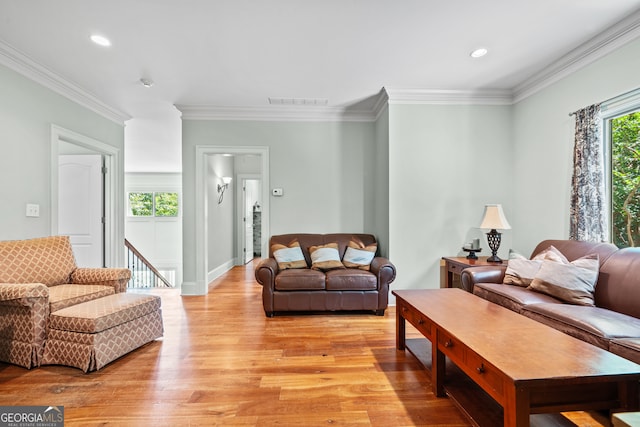 living room with light hardwood / wood-style flooring and ornamental molding