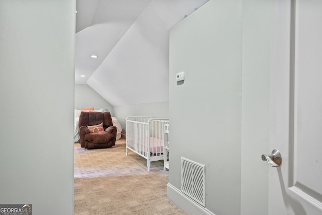 bedroom with light carpet, vaulted ceiling, and a nursery area