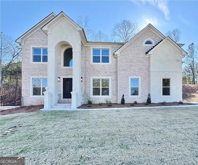 view of front of property featuring brick siding and a front yard