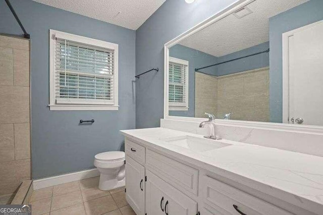 bathroom with toilet, tile patterned flooring, a textured ceiling, and vanity