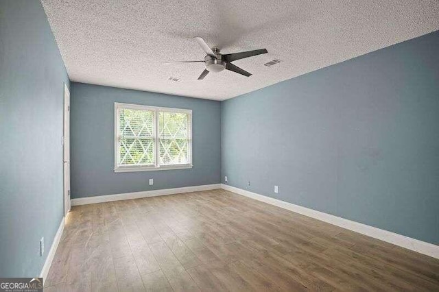 spare room with hardwood / wood-style flooring, a textured ceiling, and ceiling fan