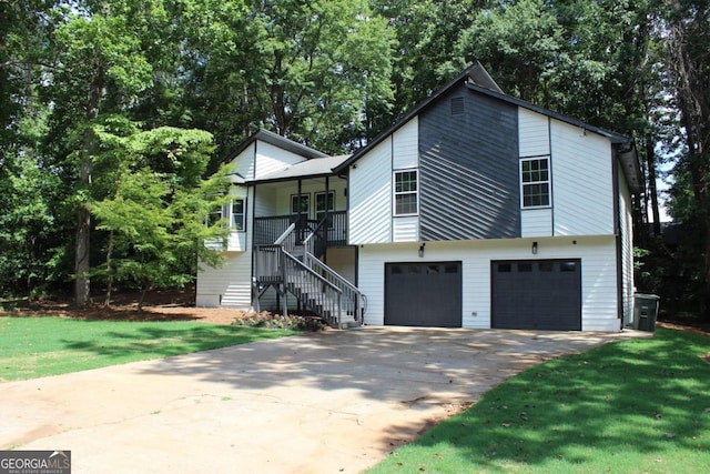 view of front of property with a garage, covered porch, and a front lawn