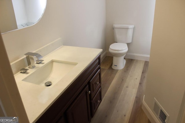 bathroom featuring vanity, wood-type flooring, and toilet