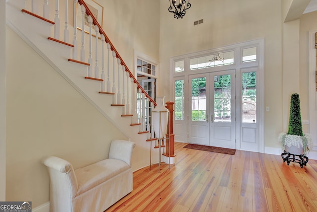 foyer featuring a high ceiling, hardwood / wood-style flooring, and french doors