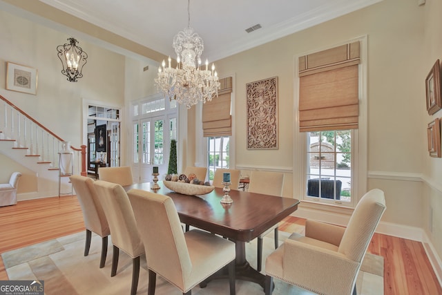 dining area featuring light hardwood / wood-style floors, crown molding, and a healthy amount of sunlight