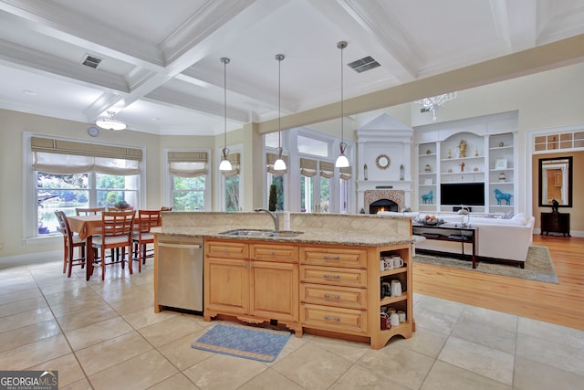 kitchen with sink, pendant lighting, stainless steel dishwasher, light stone counters, and light tile patterned floors