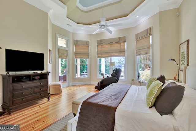 bedroom featuring crown molding, multiple windows, light wood-type flooring, and ceiling fan