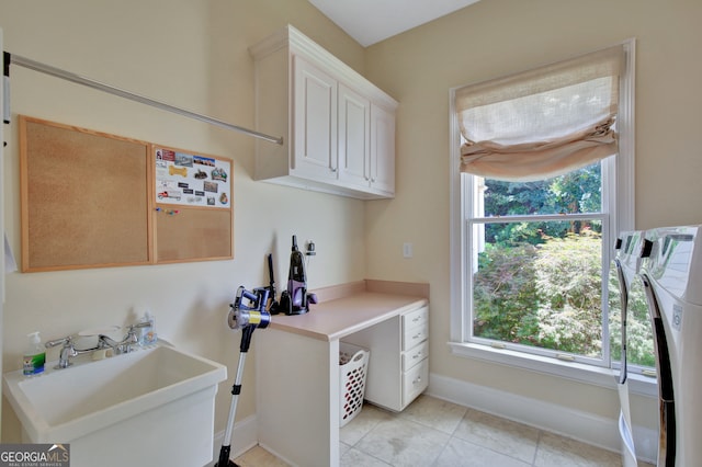 clothes washing area with cabinets, sink, washing machine and dryer, and light tile patterned floors