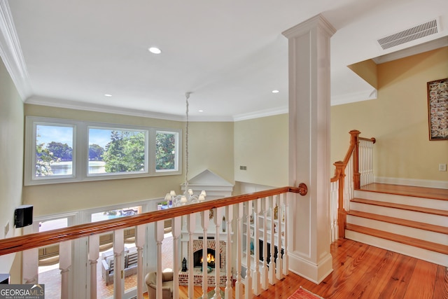 hallway featuring light hardwood / wood-style flooring, a notable chandelier, and crown molding