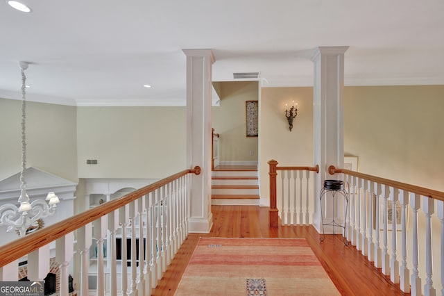 hall featuring crown molding, a notable chandelier, and light hardwood / wood-style floors