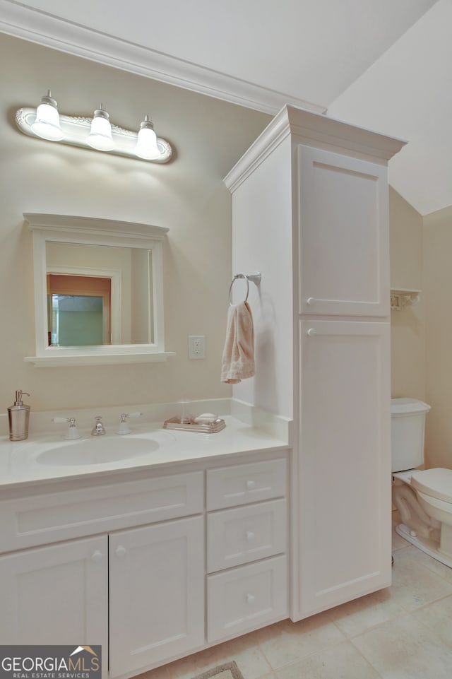 bathroom featuring vanity, lofted ceiling, toilet, and tile patterned floors