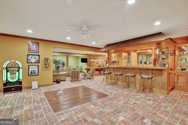 interior space featuring crown molding, indoor bar, and ceiling fan