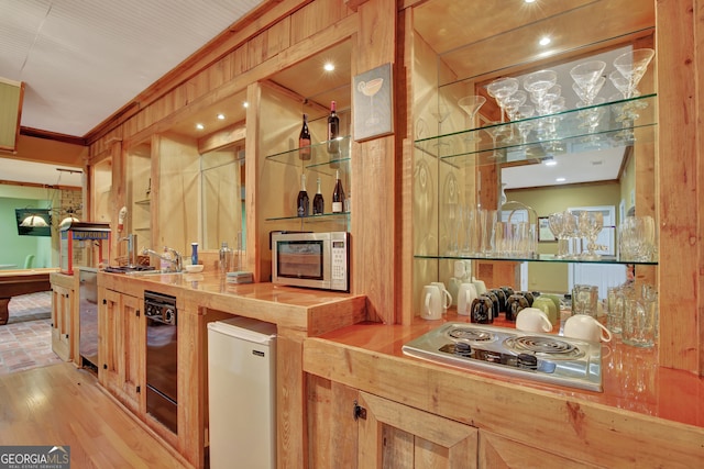 kitchen featuring crown molding, butcher block counters, white fridge, and light hardwood / wood-style flooring